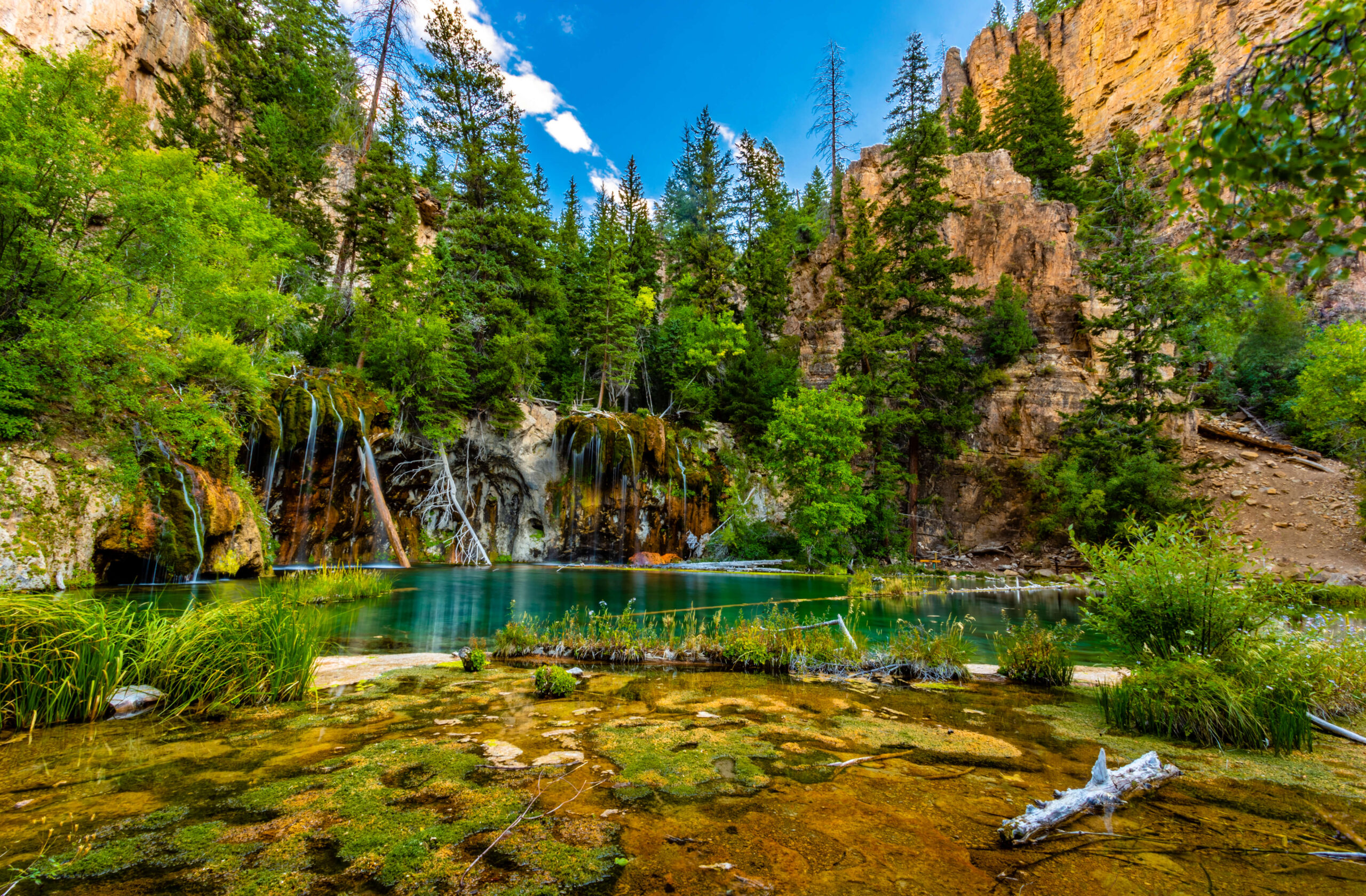 This photo is a picture of Hanging Lake. The colors are very vibrant.