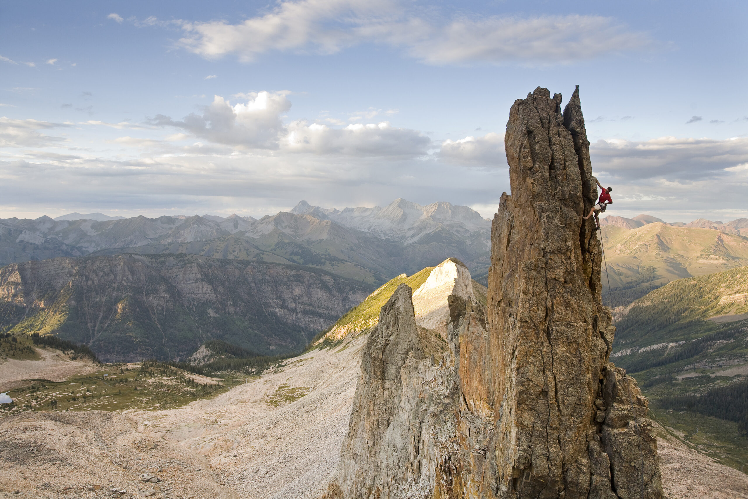 In this photo, at an elevation of 13,000 feet in the Elk Mountain Range, Michael Schneiter stands triumphantly atop a spire on Treasure Mountain.