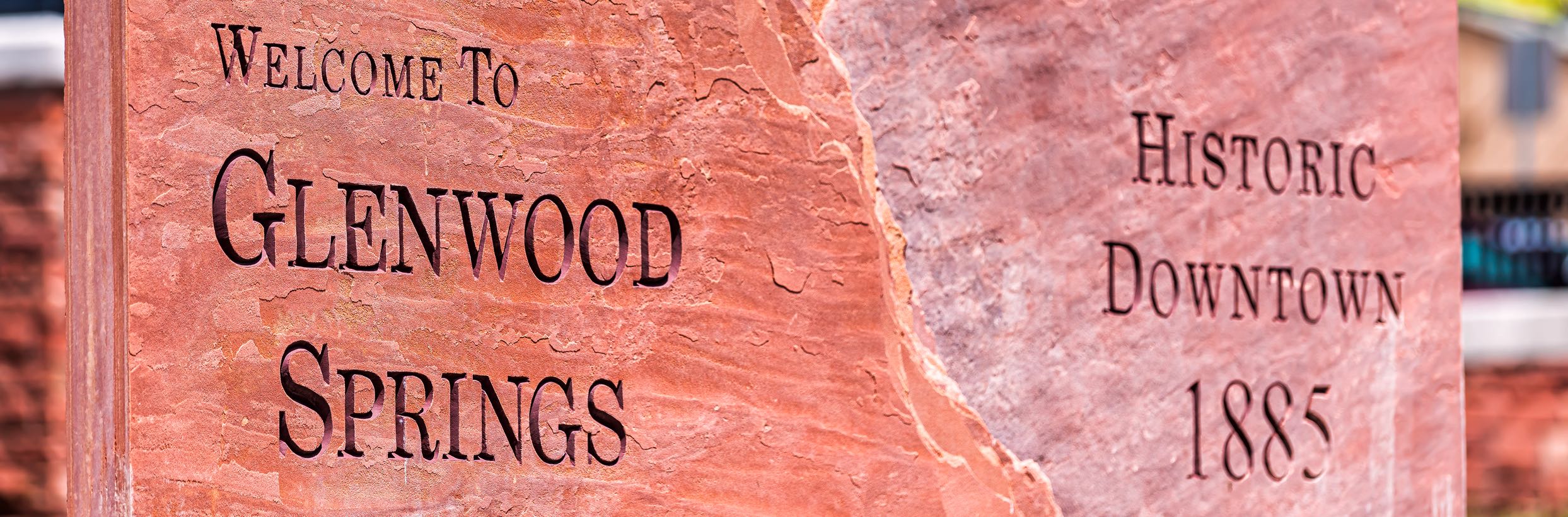A welcoming rock sign bearing the inscription "Welcome to Glenwood Springs" and "Historic Downtown 1885."