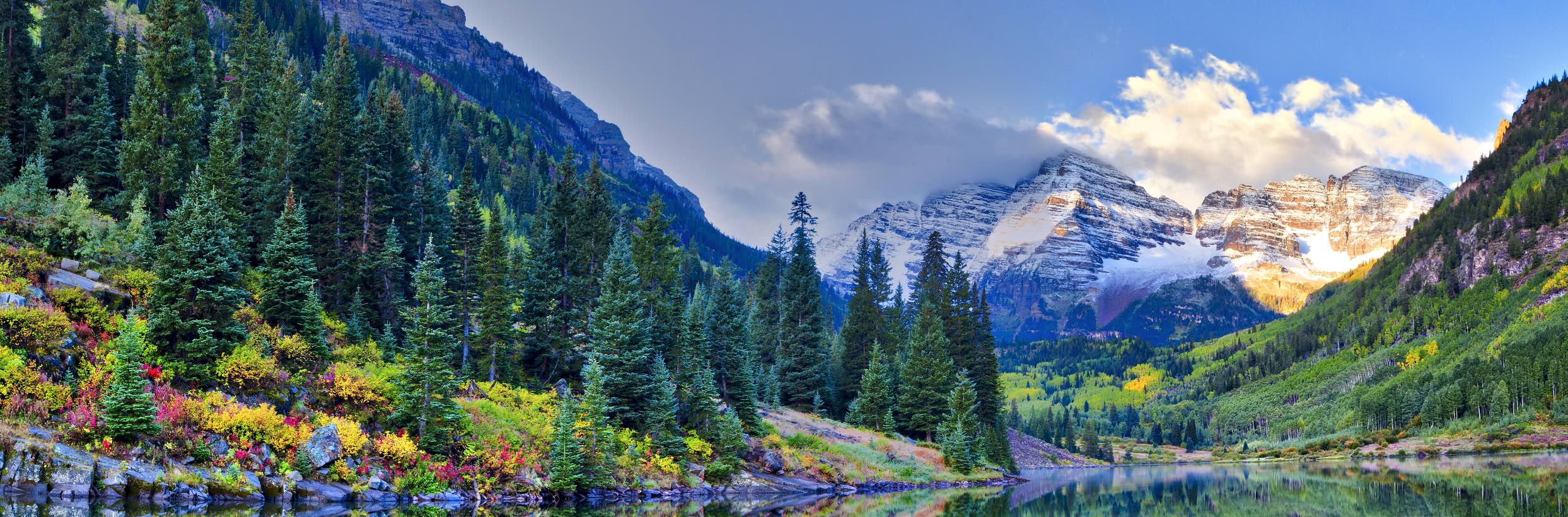 This iconic photo of the Maroon Bells showcases the majestic peaks framed by a surrounding forest and a delicate dusting of snow.
