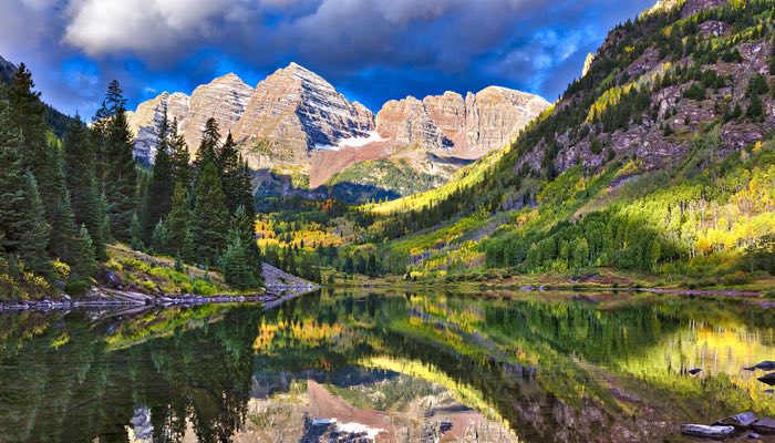 Captured in this image are the Maroon Bells in Aspen, Colorado, showcasing the distant, majestic peaks mirrored in the pristine waters of Maroon Lake.