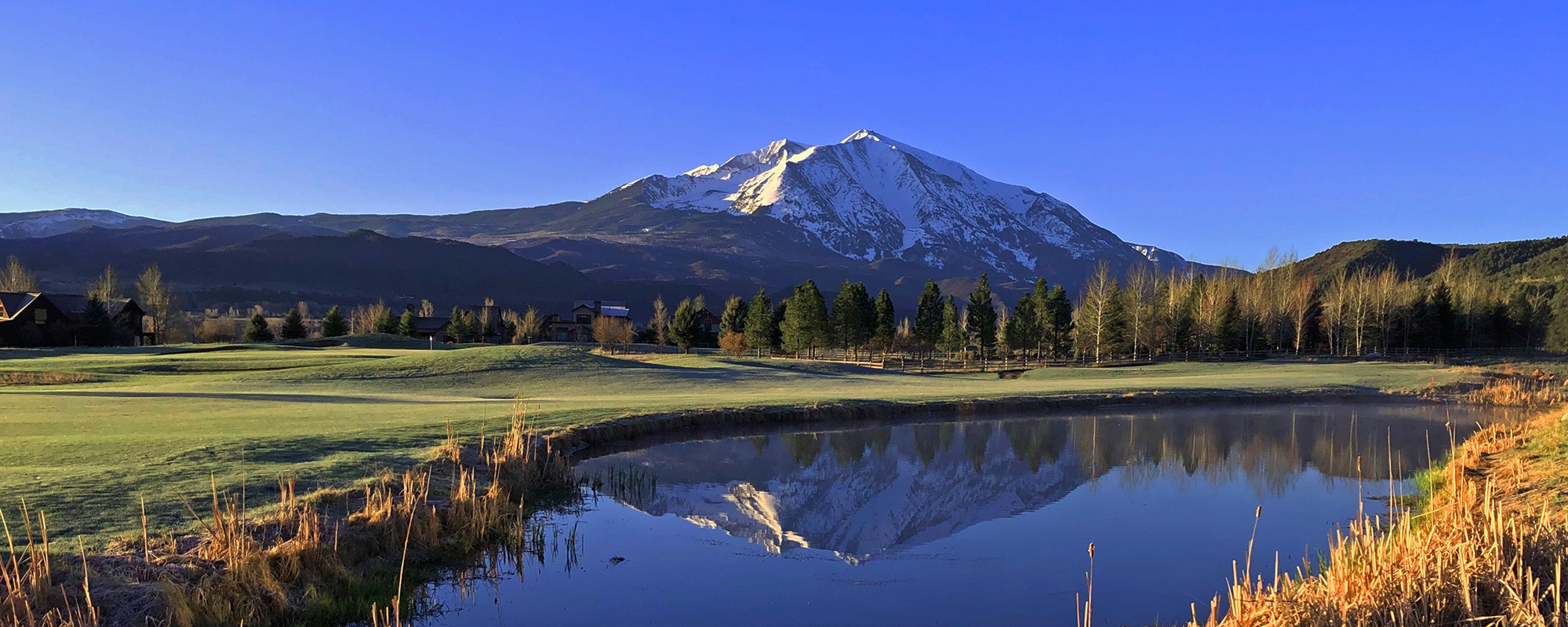 Capturing the scenic beauty of River Valley Ranch's golf course, this photo features Mt. Sopris gracing the background. The course includes a picturesque pond that perfectly mirrors the majestic mountain views, creating a captivating and beautiful scene.
