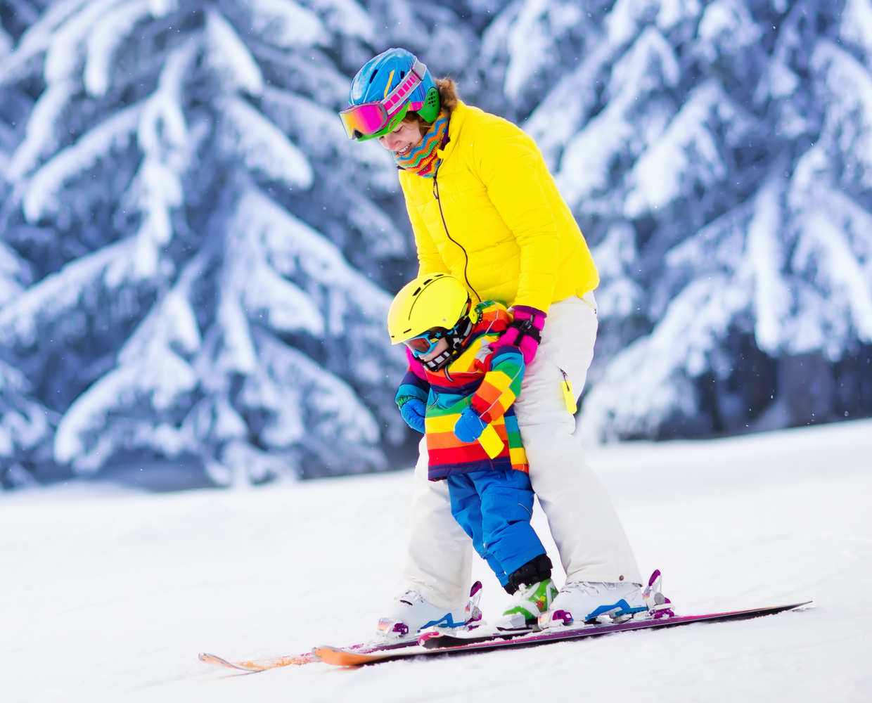 A mother and her young child relish the experience of skiing at Sunlight Mountain Resort, donned in vibrant ski gear rented from Hanging Lake Adventure Co-op. Their bright-colored attire makes them easily noticeable as they traverse the slopes.